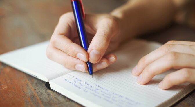 closeup shot of a hand with a blue pen